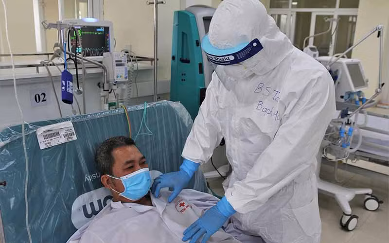 BS Toàn kiểm tra tình hình sức khỏe cho bệnh nhân COVID-19 trong phòng ICU (chăm sóc tích cực).