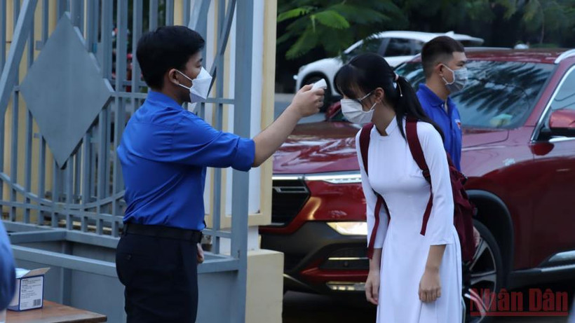 Đo thân nhiệt cho học sinh trước khi vào lớp học trực tiếp tại Đồng Nai. 