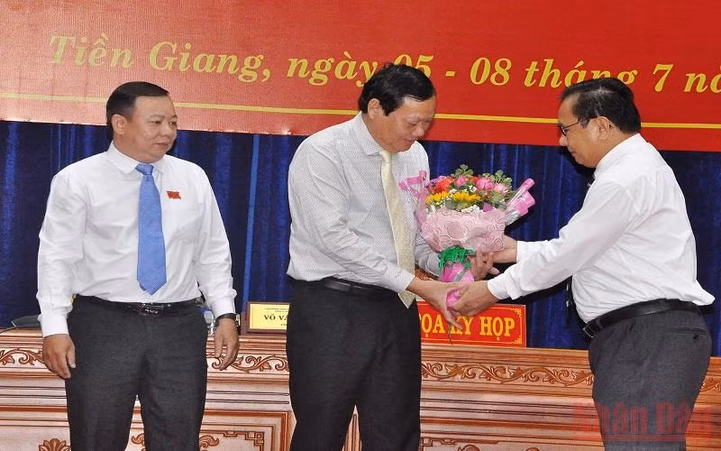 Đồng chí Võ Văn Bình, Phó Bí thư Thường trực Tỉnh ủy, Chủ tịch Hội đồng nhân dân tỉnh Tiền Giang tặng hoa chúc mừng đồng chí Nguyễn Hữu Lợi.