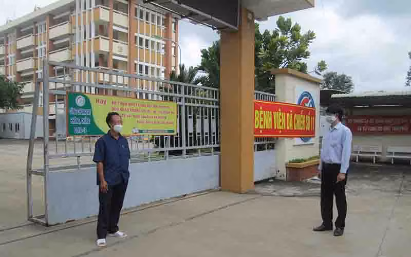 Thầy Đàm Văn Tuyến, Hiệu trưởng trường THPT chuyên Long An (phải) thăm trường trong mùa dịch trước ngày khai giảng năm học mới và trò chuyện với Phó giám đốc Bệnh viện dã chiến số 11 đặt ngay tại trường. 