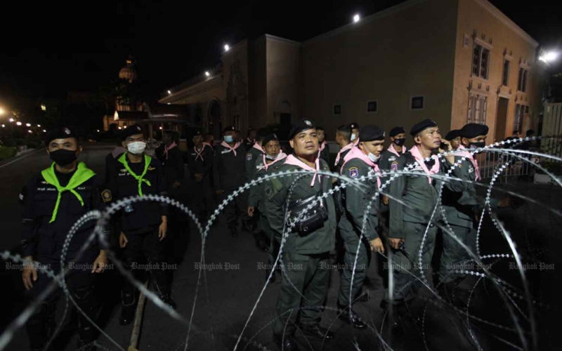 Cảnh sát Thái Lan bảo vệ Tòa nhà Chính phủ ở Thủ đô Bangkok khi người biểu tình tập hợp ở phía ngoài vào đêm 14-10. (Ảnh: Bangkok Post)