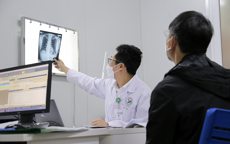 Bác sĩ Đinh Thế Tiến khám cho bệnh nhân hậu Covid-19.