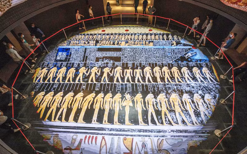 Du khách tới chiêm ngưỡng một bộ sưu tập vàng ròng của Kho báu Douche từ thời La Mã, được trưng bày trong tủ kính tại Bảo tàng Văn minh Quốc gia Ai Cập mới ở Old Cairo. (Ảnh: AP)