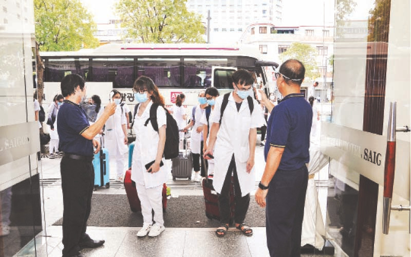 Đoàn y, bác sĩ tại sân vườn khách sạn Continental Sài Gòn trong thời gian kiểm tra y tế, chờ nhận phòng.