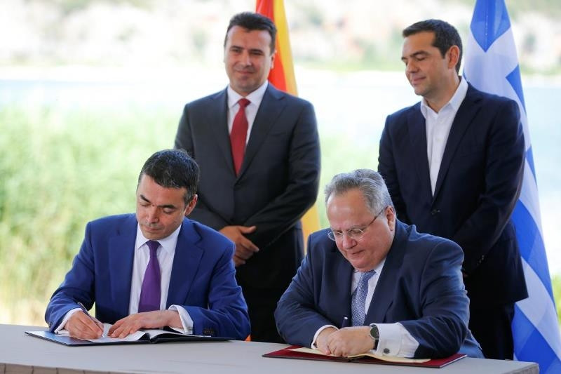 Bộ trưởng Ngoại giao Hy Lạp Nikos Kotzias và người đồng cấp Macedonia Nikola Dimitrov ký thỏa thuận lịch sử trước sự chứng kiến của hai Thủ tướng. (Ảnh: Reuters)