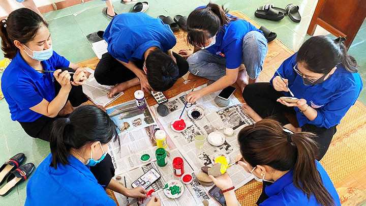 Các bạn trẻ đoàn viên thị trấn Thạch Giám cùng vẽ tác phẩm nghệ thuật trên đá.