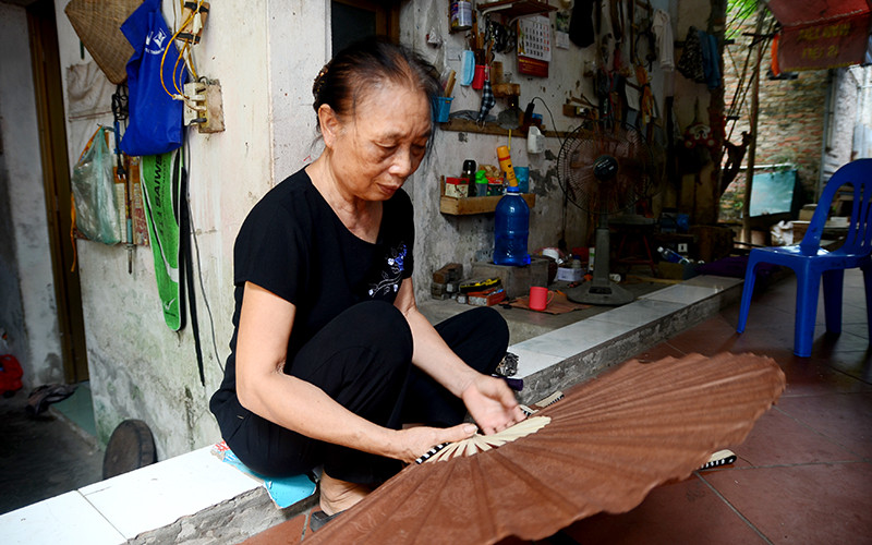 Bà Trần Thị Công với chiếc quạt sừng giấy dó.