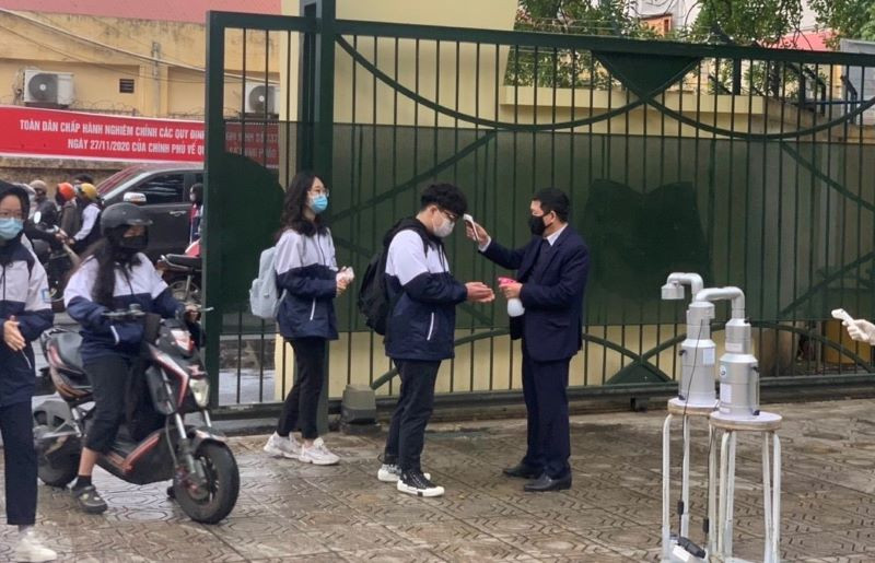 Kiểm tra thân nhiệt cho học sinh vào sáng ngày 2-3 tại Trường THPT Nguyễn Gia Thiều (Long Biên, Hà Nội)