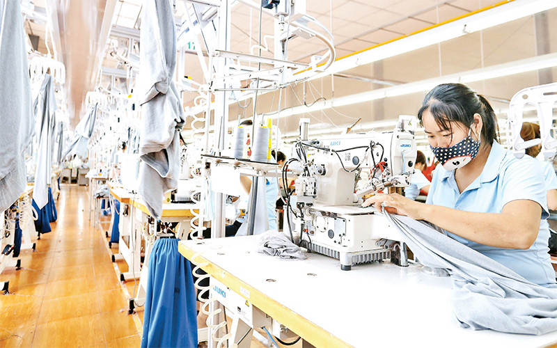 Công nhân Công ty cổ phần may Sông Hồng (Nam Ðịnh) trong giờ làm việc. (Ảnh: TRẦN GIANG)