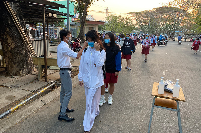 Đo thân nhiệt học sinh khi đến trường.