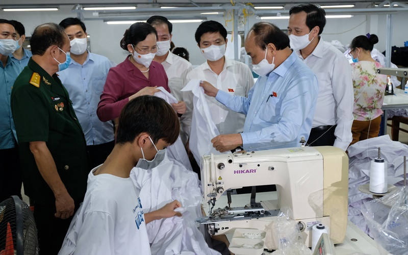 Ngày 23/7, Chủ tịch nước Nguyễn Xuân Phúc đến thăm doanh nghiệp may mặc Hoàng Tuyên tại tỉnh Hà Nam, do thương binh làm kinh tế giỏi Hoàng Văn Tuyên làm chủ. (Ảnh: Đào Phương)