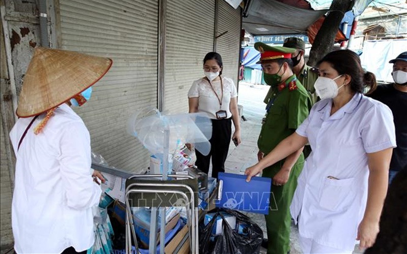 Lực lượng chức năng phường Đồng Xuân, quận Hoàn Kiếm phát hiện, lập biên bản xử lý một trường hợp bán rong khẩu trang không rõ nguồn gốc, vi phạm quy định phòng, chống dịch. (Ảnh: TTXVN)