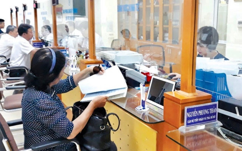 Cán bộ UBND quận Hoàn Kiếm tiếp nhận, hướng dẫn người dân làm thủ tục hành chính tại bộ phận “Một cửa”.