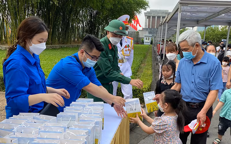 Người dân phấn khởi nhận các phần quà sau khi vào Lăng viếng Bác.