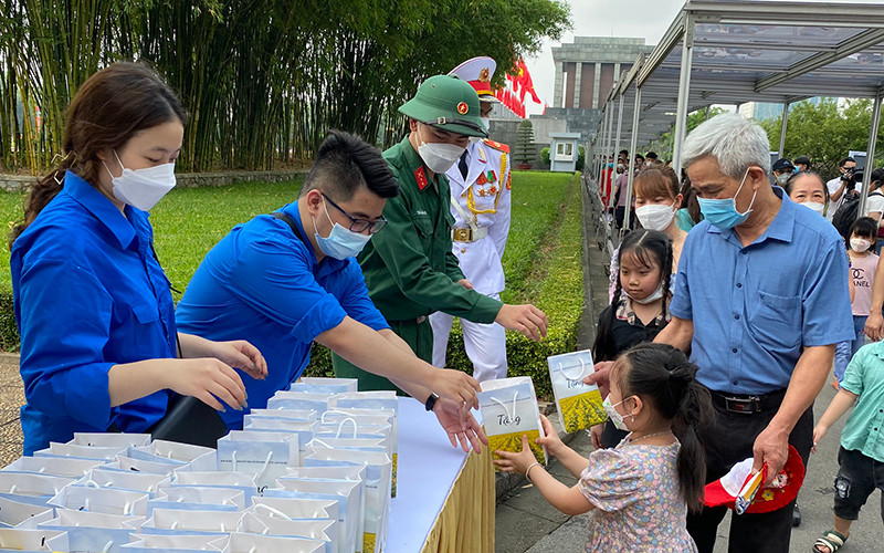 Người dân phấn khởi nhận các phần quà sau khi vào Lăng viếng Bác.