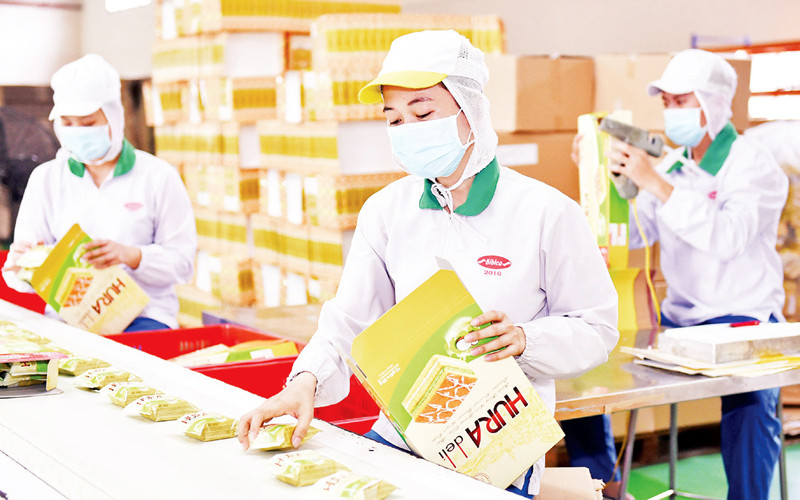 Công nhân Công ty cổ phần Bibica đóng gói sản phẩm phục vụ hàng Tết (Ảnh minh họa: Phương Vy).