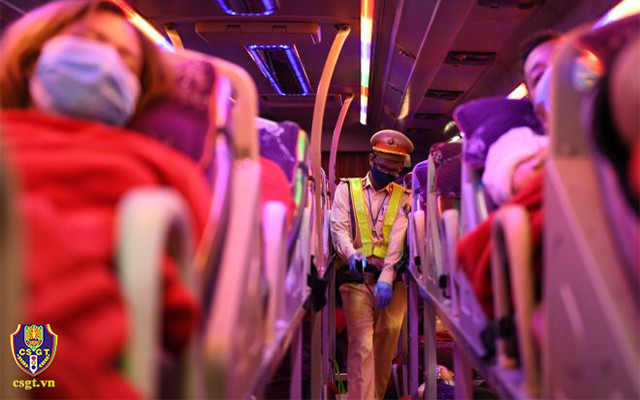 Chiến sĩ cảnh sát giao thông nhắc nhở hành khách trên xe thắt dây an toàn. (Ảnh: Cục CSGT)