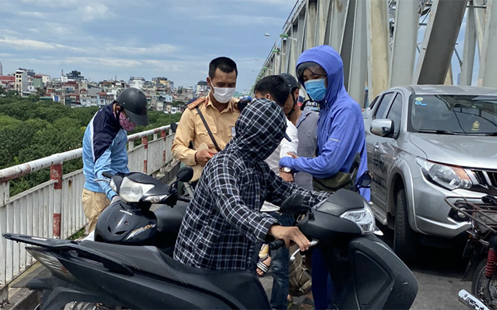 Cảnh sát giao thông phối hợp với người dân ngăn chặn nam thanh niên (áo trắng) nhảy cầu tự tử.