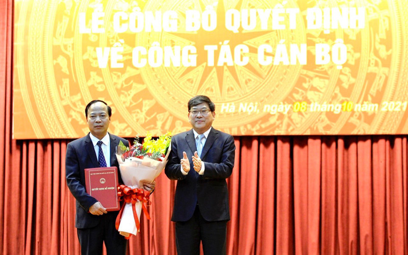 PGS, TS Nguyễn Duy Bắc, Phó Bí thư Đảng ủy, Phó Giám đốc Học viện Chính trị quốc gia Hồ Chí Minh trao quyết định và tặng hoa chúc mừng PGS, TS Mai Đức Ngọc.