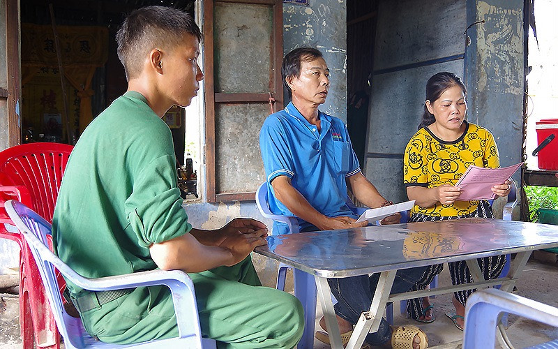 Bà Danh Thị Bé Tư (áo vàng), mẹ quân nhân Huỳnh Thanh Hiếu (Trung đoàn 20, Sư đoàn 330, Quân khu 9) đọc thư của đơn vị gửi trong thời gian con mình được nghỉ phép.