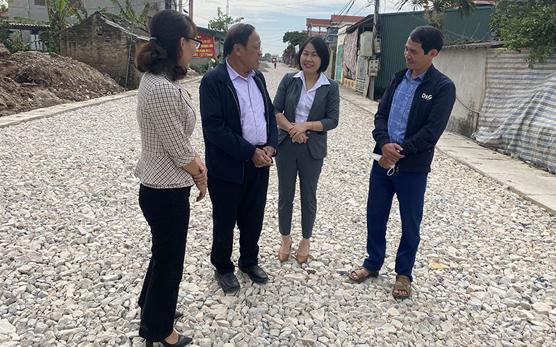 Cựu chiến binh Phạm Văn Vạn (người thứ hai từ trái sang) trao đổi với các cán bộ huyện và tỉnh về kinh nghiệm vận động nhân dân hiến đất làm đường giao thông tại xã Quỳnh Ngọc. 