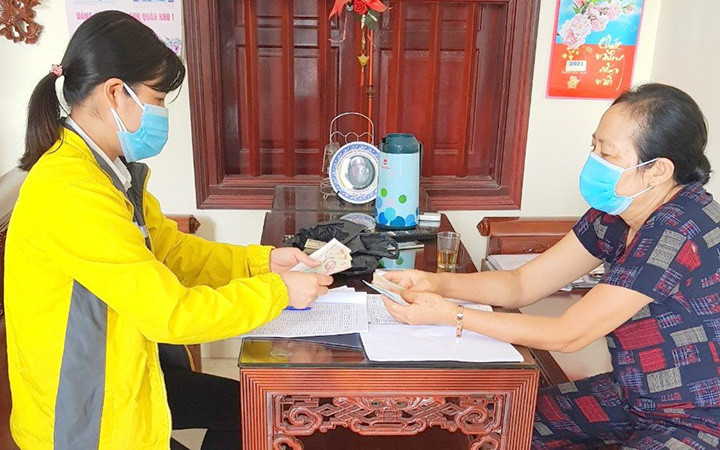 Chi trả lương hưu tại nhà (Ảnh: Bảo hiểm xã hội Hà Nội).