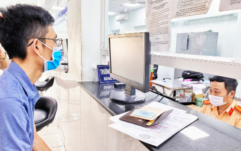 Lực lượng CSGT thành phố Hồ Chí Minh làm thủ tục cấp đổi biển số mầu vàng cho người dân tại điểm đăng ký xe số 282 Nơ Trang Long, quận Bình Thạnh.
