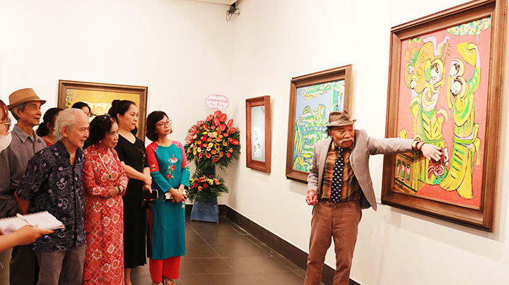 Họa sĩ Nguyễn Đại Giang giới thiệu tác phẩm với người xem.