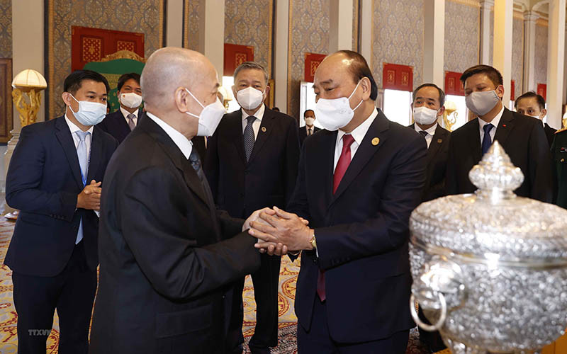 Chủ tịch nước Nguyễn Xuân Phúc và Quốc vương Campuchia Norodom Sihamoni giới thiệu về của quà tặng của hai nước tại Cung điện Hoàng gia. (Ảnh: TTXVN)