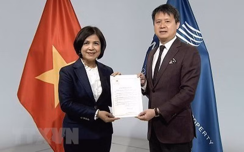 Đại sứ Lê Thị Tuyết Mai trao văn kiện Việt Nam gia nhập Hiệp ước WIPO về buổi biểu diễn và bản ghi âm cho Tổng giám đốc WIPO Daren Tang. (Ảnh: TTXVN)