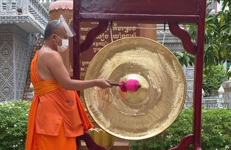 Một nhà sư đánh cồng nhắc nhở người dân thực hiện các biện pháp phòng, chống dịch tại Phnom Penh, sáng 25-3 (Ảnh: Fresh News) 