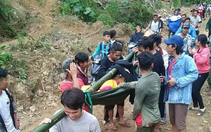 Người làng ở thôn Tre, xã Trà Tây gánh người bệnh ra đường lớn đón xe cấp cứu.