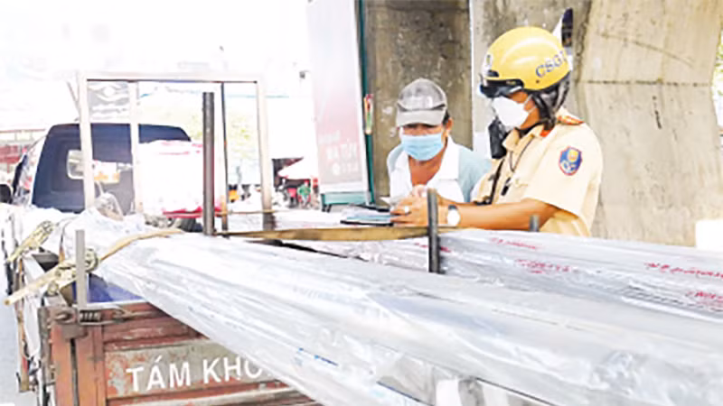 Hầu hết các xe ba, bốn bánh tự chế chuyên chở hàng hóa lưu thông trên đường đều không có giấy tờ và biển kiểm soát. Trong ảnh: CSGT thành phố kiểm tra xe cơ giới ba bánh chở hàng hóa sai quy định.