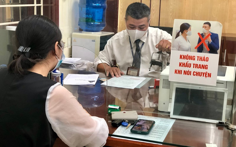 Cán bộ tư pháp hộ tịch phường Vĩnh Tuy, quận Hai Bà Trưng thực hiện ký chứng thực và đóng dấu hồ sơ theo quy định mới.