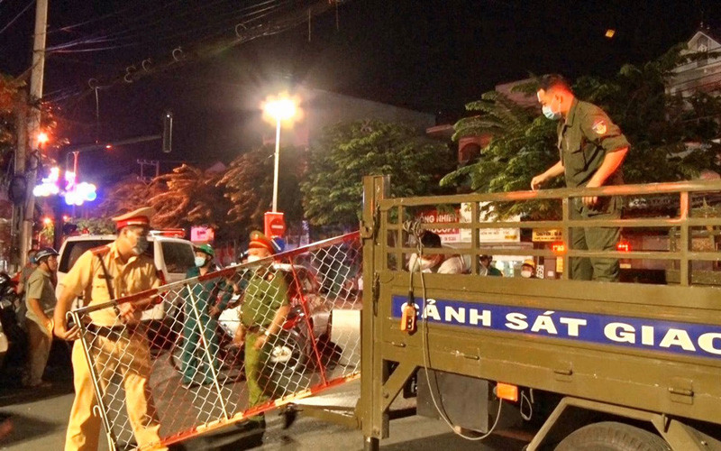 Lực lượng chức năng di chuyển hàng rào phong tỏa lên xe. 