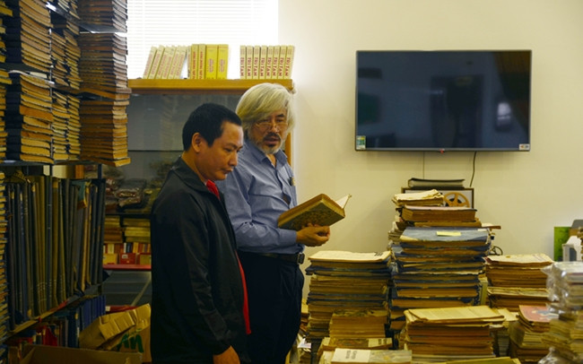 Ông Nguyễn Phi Dũng (bên phải) giới thiệu về bộ sưu tập của mình.