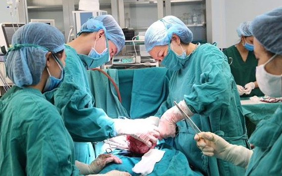 Các bác sĩ tiến hành cắt khối u cho người bệnh.