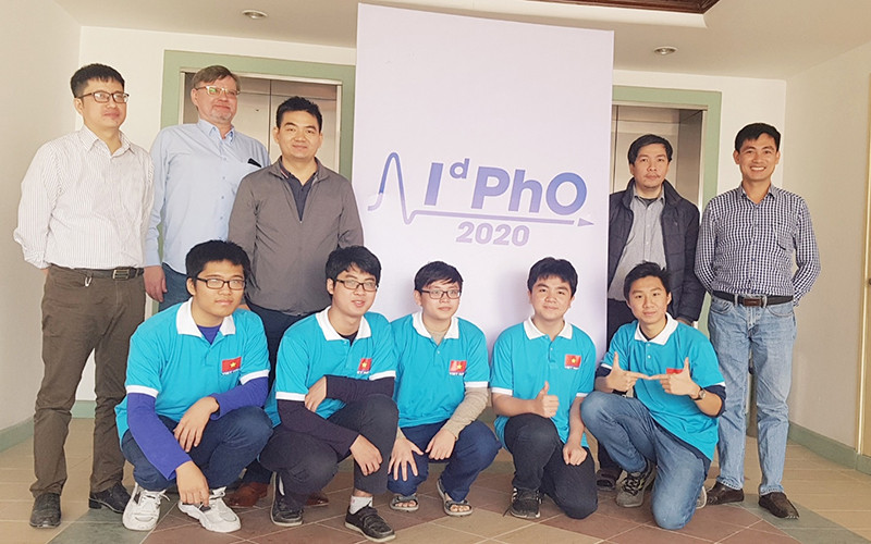 Từ trái qua phải: TS. Dương Quốc Văn, ông Dmitry (giám sát kỳ thi), PGS.TS. Nguyễn Cao Khang (trưởng đoàn), thầy Nguyễn Bảo Trung, TS. Nguyễn Công Toản (Quan sát viên) và năm em học sinh đoạt giải.