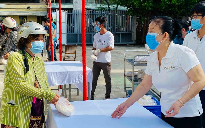 Bà Le Thị Kim Thu, đại diện Đại lý vé số Trương Thị Ngọc Thủy tặng quà cho người dân.