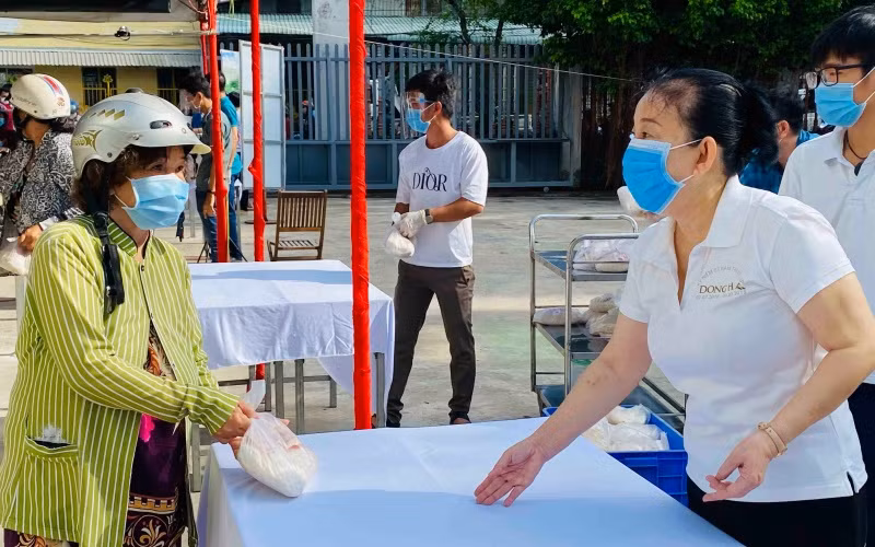 Bà Le Thị Kim Thu, đại diện Đại lý vé số Trương Thị Ngọc Thủy tặng quà cho người dân.