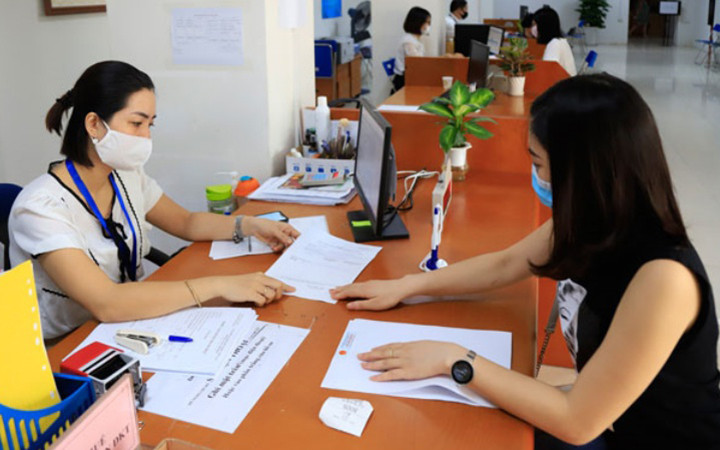 Cán bộ Cục Thuế Hà Nội hướng dẫn doanh nghiệp làm thủ tục hành chính (Ảnh minh họa).