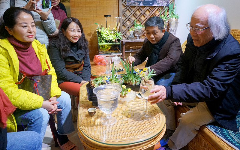 Nghệ nhân Nguyễn Phú Cường (ngoài cùng bên phải) hướng dẫn cách chăm sóc hoa thủy tiên.