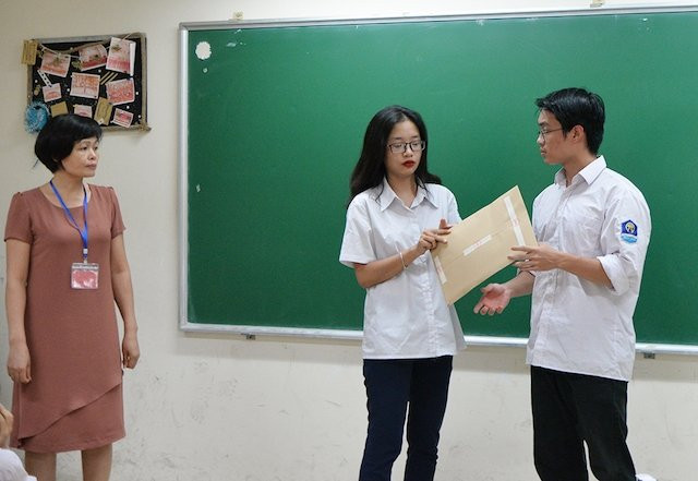 Thí sinh thực hiện kiểm tra niêm phong túi đề thi tại Kỳ thi THPT quốc gia năm 2019 (Ảnh: THUỶ NGUYÊN)