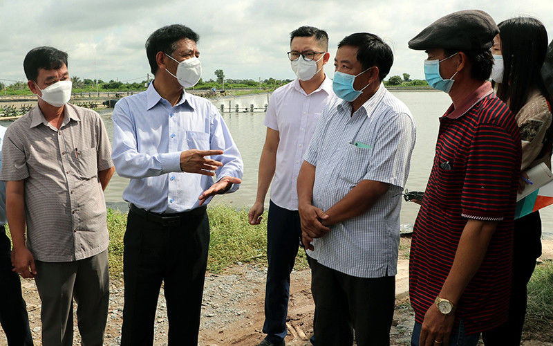 Đồng chí Lâm Văn Mẫn (thứ hai từ trái sang) gặp gỡ nông dân nuôi tôm.