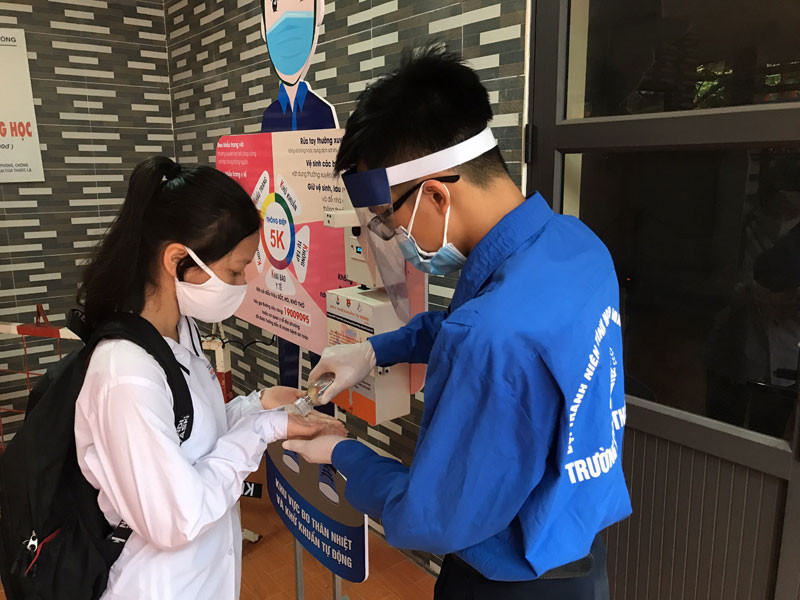 Các thí sinh được kiểm tra thân nhiệt và sát khuẩn tay trước khi vào phòng thi.