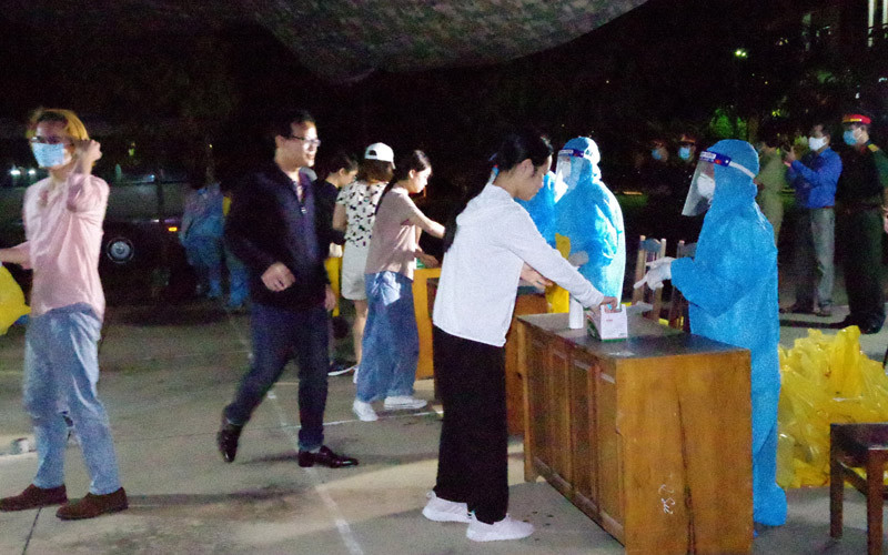 Các công dân nhận khẩu trang và làm thủ tục trước khi vào khu cách ly