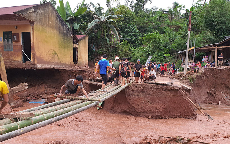 Lực lượng cứu hộ khẩn trương làm cầu tạm thay ngầm Nậm Nhừ 1 đã bị lũ cuốn trôi.