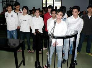 Hạnh “Nhật” (áo kẻ ngang, gần vành móng ngựa),
Ánh “Phú” (thứ 3 từ trái sang, hàng thứ 2)
và đồng bọn trước Tòa.