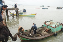 Bà con ngư dân vớt tàu đánh cá<br>bị đắm và thu dọn ngư cụ<br>tại bến Sao Mai, Vũng Tàu.
(Ảnh: Quang Bình)