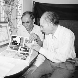 Ông Nguyễn Thanh Dương (bên trái) giới thiệu
bộ sưu tập ảnh Bác Hồ gần 60 năm qua.